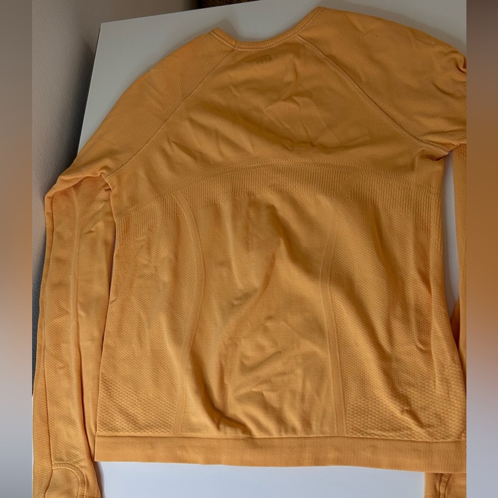 Super cute orange Athleta long sleeve swiftly. perfect condition. Size 8-10